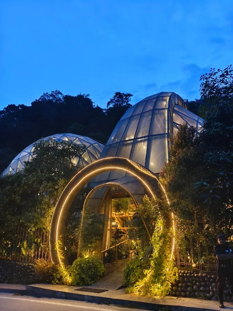 The lit circular archway at the entrance of Queen's Pod at blue hour