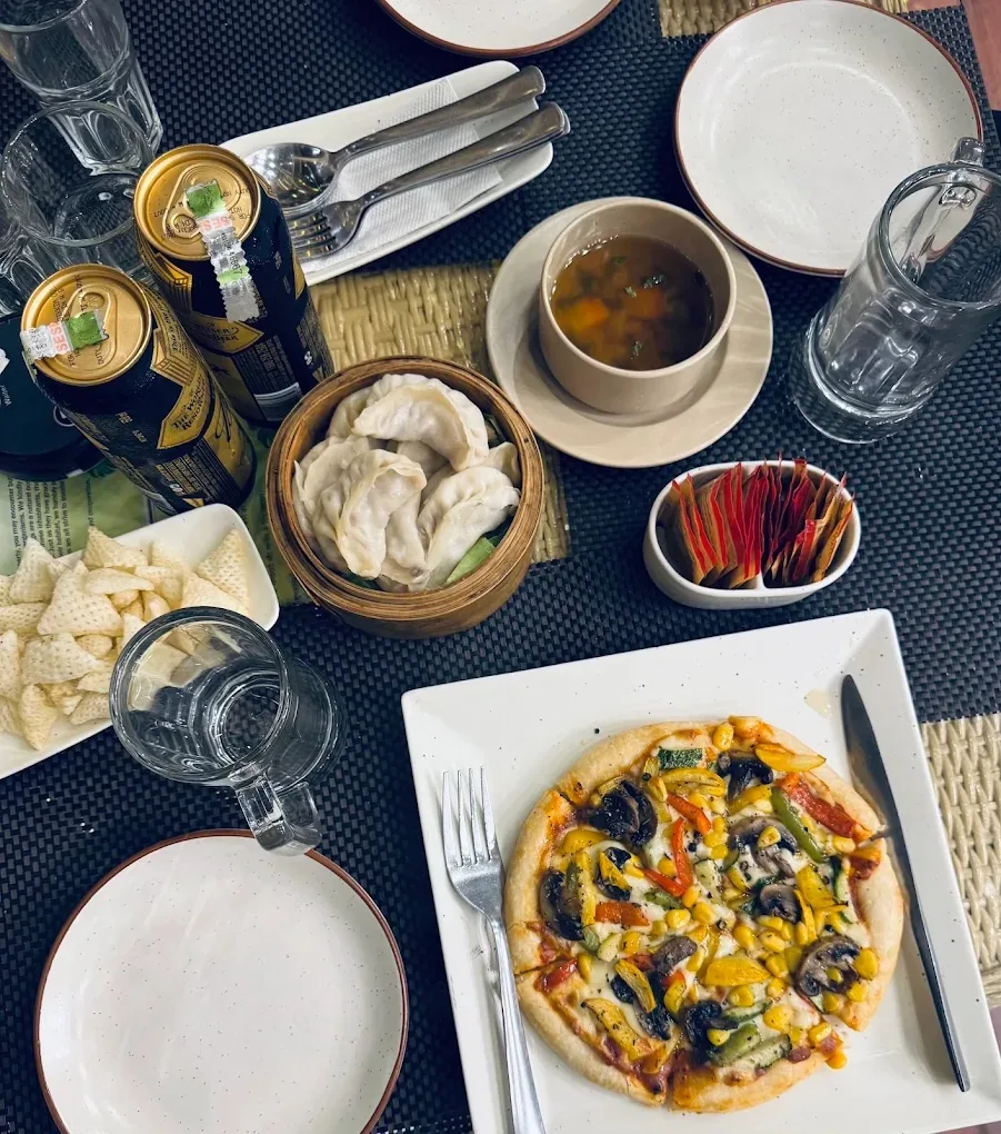A table spread of dumplings, soup and pizza